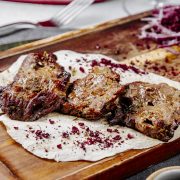 side view of roasted meat pieces on a wooden board